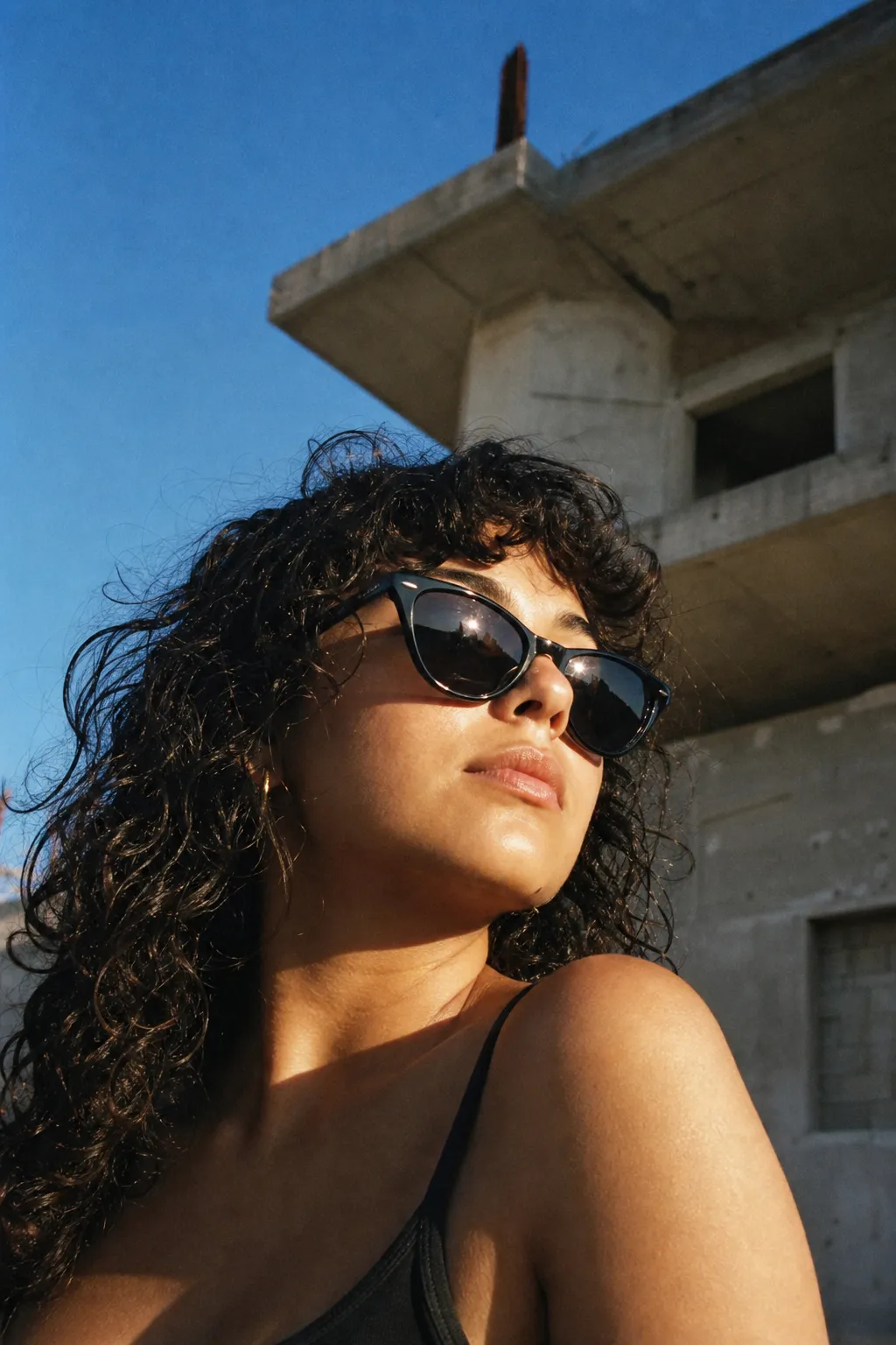 Creator in sunglasses looking up against a blue sky